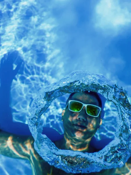 Pool Summer Party, Man Making Bubble Rings Underwater in Swimming Pool  