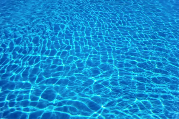 青いリップル水の背景 スイミングプールの水の太陽の反射 — ストック写真