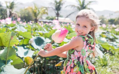 Bu güzel Nilüfer veya lotus çiçeği. Kızı tutun onun elinde bir çiçek ve gülümseme.