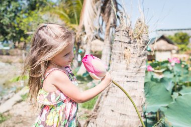 Bu güzel Nilüfer veya lotus çiçeği. Kız onun elinde bir çiçek tutun, o burnunu çekmek ve gülümseme.