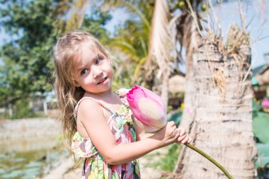 Bu güzel Nilüfer veya lotus çiçeği. Kızı tutun onun elinde bir çiçek ve gülümseme.
