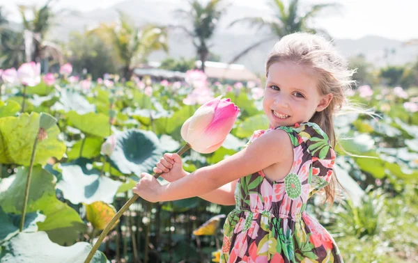 Bu güzel Nilüfer veya lotus çiçeği. Kızı tutun onun elinde bir çiçek ve gülümseme.