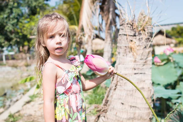 Bu güzel Nilüfer veya lotus çiçeği. Kızı tutun onun elinde bir çiçek ve gülümseme.