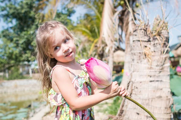 Bu güzel Nilüfer veya lotus çiçeği. Kızı tutun onun elinde bir çiçek ve gülümseme.