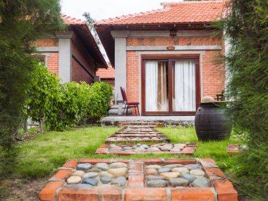 Kırmızı tuğla, kil küvet su, taş yolu ile panoramik pencereli oryantal tarzı tek katlı evi