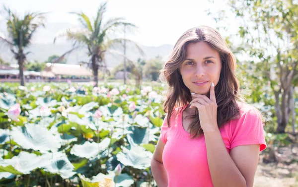 Genç kız kalın lotus gölet ve gülümseme