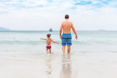 Baba ve küçük kızı sahilde yürümek