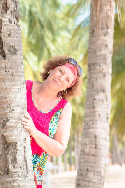 Portrait d'une heureuse femme âgée souriante debout près du palmier — Photo