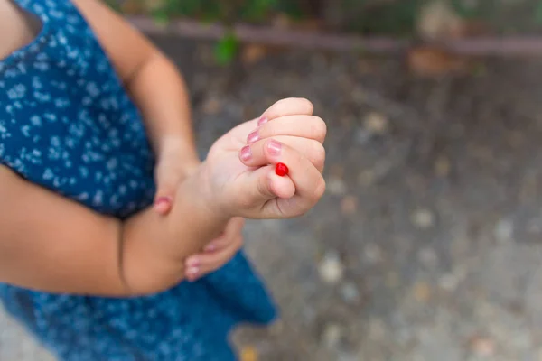 La mano de una chica. bayas rojas yacen en la palma de un niño — Foto de Stock