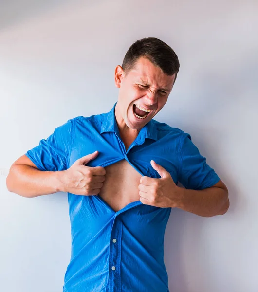 Businessman tearing off his shirt and showing mucular body concept on background