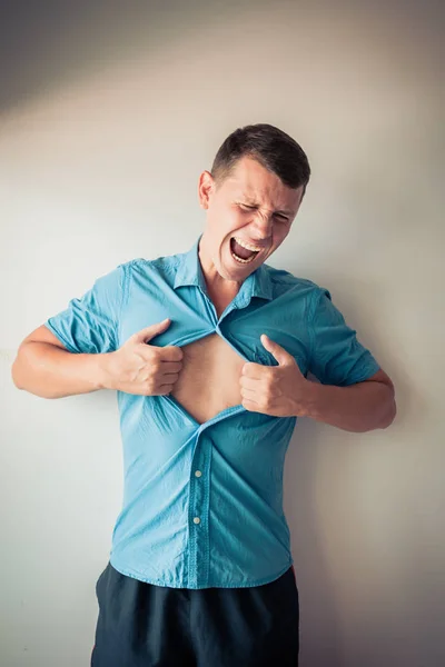 그의 셔츠 떨어져 찢기 고 배경에 mucular 신체 개념을 보여주는 사업가 스톡 사진