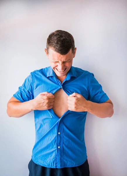 Businessman tearing off his shirt and showing mucular body concept on background