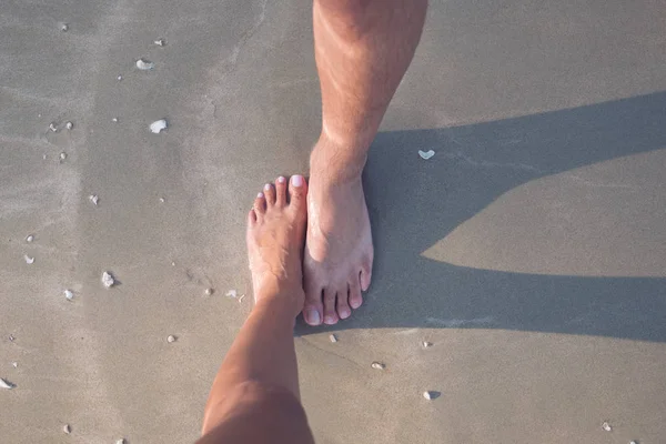 Jeden samec a jedna ženská noha na písku — Stock fotografie