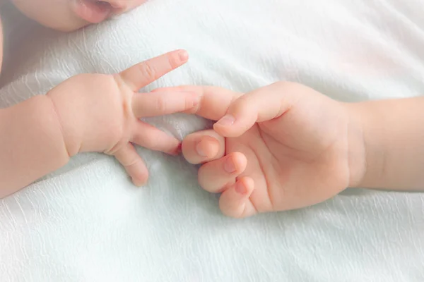 Händerna på barnet och lilla flickan. två spädbarn händer Stockfoto