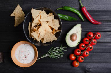 Koyu arka plan üzerinde soslar ile Meksika nachos