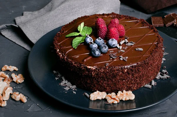 Schokoladenkuchen mit frischen Beeren und Nüssen Stockbild