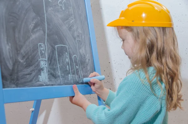 儿童工程师 设计师 戴头盔的女孩在黑色粉笔板上粉刷房子 — 图库照片