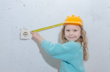 çocuk işçisi, Builder, bir kask kız bir bant ölçüsü ile mesafe ölçer