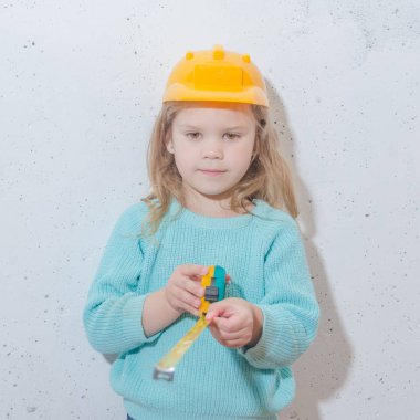 çocuk işçisi, Builder, bir kask kız bir bant ölçüsü ile mesafe ölçer
