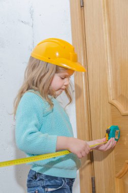 çocuk işçisi, Builder, bir kask kız bir bant ölçüsü ile mesafe ölçer