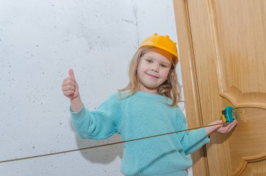 çocuk işçisi, Builder, bir kask kız bir bant ölçüsü ile mesafe ölçer