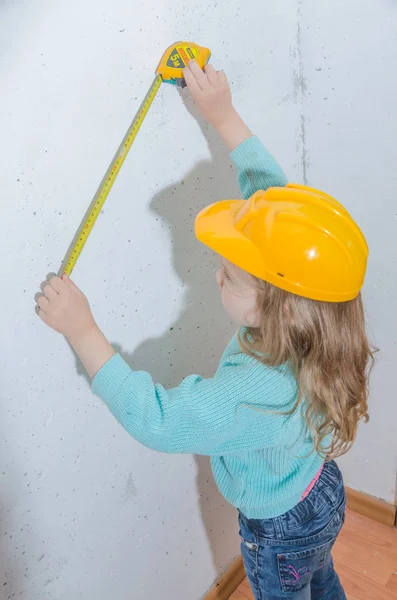 çocuk işçisi, Builder, bir kask kız bir bant ölçüsü ile mesafe ölçer
