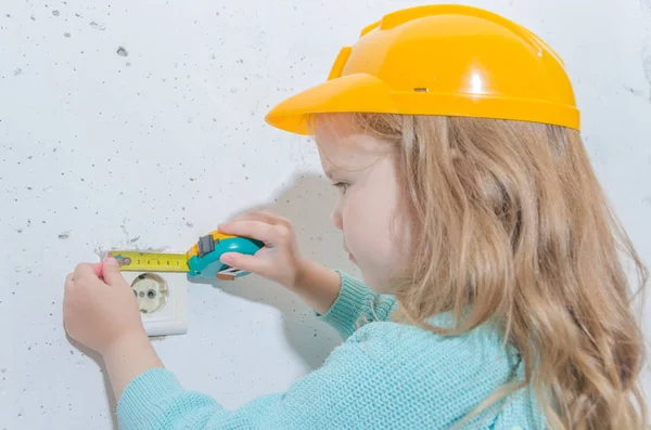 çocuk işçisi, Builder, bir kask kız bir bant ölçüsü ile mesafe ölçer