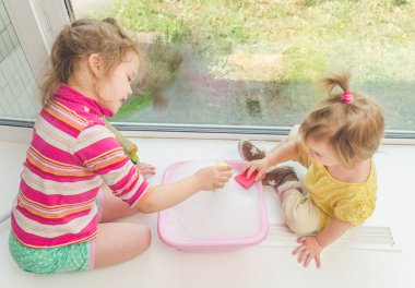 Kız, Pencere pervazı bir çocuğun pencerenin güneşli bir günde yıkar