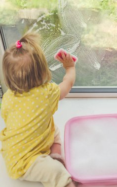 Kız, Pencere pervazı bir çocuğun pencerenin güneşli bir günde yıkar