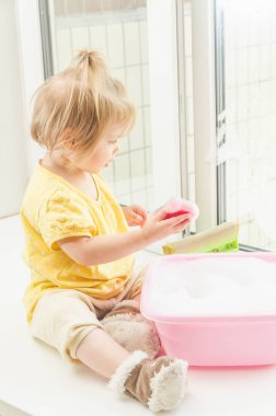 Kız, Pencere pervazı bir çocuğun pencerenin güneşli bir günde yıkar