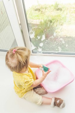 Kız, Pencere pervazı bir çocuğun pencerenin güneşli bir günde yıkar