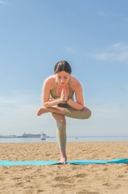 Yoga yaparken, Asanalar suya yakın sahilde park yaparken kız