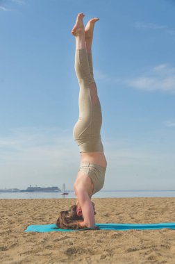 Yoga yaparken, Asanalar suya yakın sahilde park yaparken kız