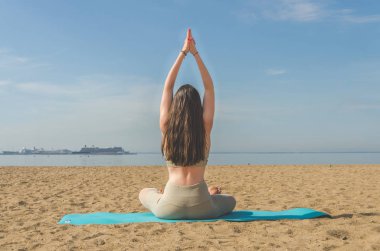 Yoga yaparken, Asanalar suya yakın sahilde park yaparken kız