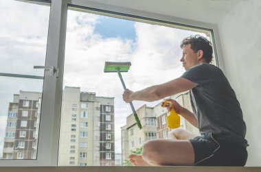 Güneşli bir günde, bir adam yıkayın pencereler