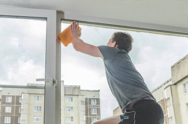 Güneşli bir günde, bir adam yıkayın pencereler