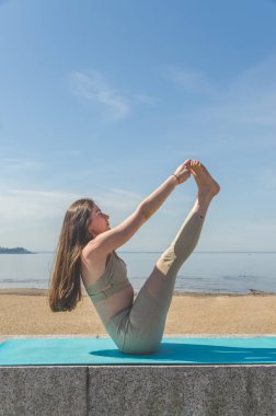 Yoga yaparken, Asanalar suya yakın sahilde park yaparken kız