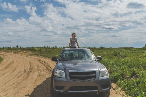 夏の日に砂浜道路でフィールドに Suv の上の美しい少女 — ストック写真