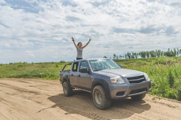 夏の日に砂浜道路でフィールドに Suv の上の美しい少女 — ストック写真