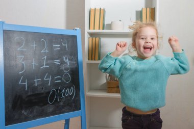 Kız, bir öğrenci bir kara tahta üzerinde matematiksel örnekler çözdü.