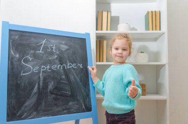 Kız, çocuk 1 Eylül yazıt ile tebeşir tahtası ve gösterileri sınıfı, mükemmel iz