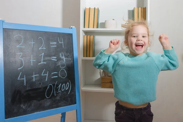 Kız, bir öğrenci bir kara tahta üzerinde matematiksel örnekler çözdü.