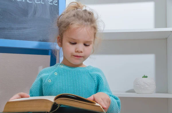 Kız, bir çocuk tebeşir tahta oturan bir kitap okuma