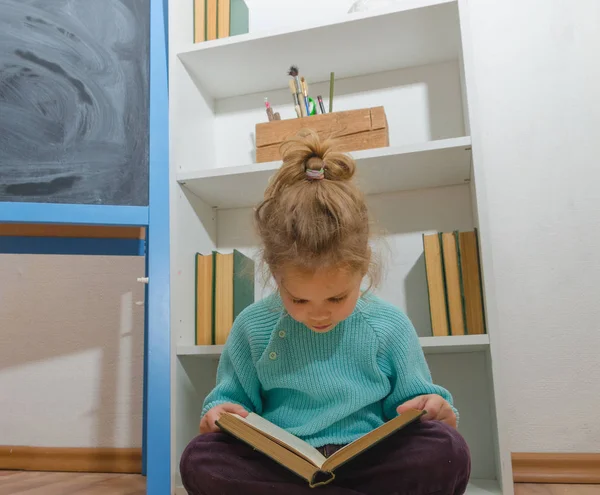 Kız, bir çocuk tebeşir tahta oturan bir kitap okuma