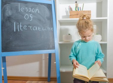 Kız, bir çocuk ile yazıt edebiyat ders kurulu tebeşir yakınındaki bir kitapla
