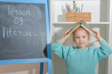 Kız, bir çocuk ile yazıt edebiyat ders kurulu tebeşir yakınındaki bir kitapla