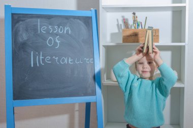 Kız, bir çocuk ile yazıt edebiyat ders kurulu tebeşir yakınındaki bir kitapla
