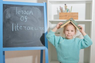 Kız, bir çocuk ile yazıt edebiyat ders kurulu tebeşir yakınındaki bir kitapla