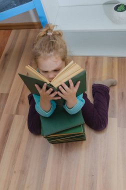 Kız, çocuk, ilkokul öğrencisi bir kitapla