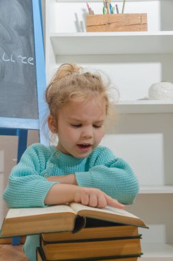 Kız, çocuk, ilkokul öğrencisi bir kitapla